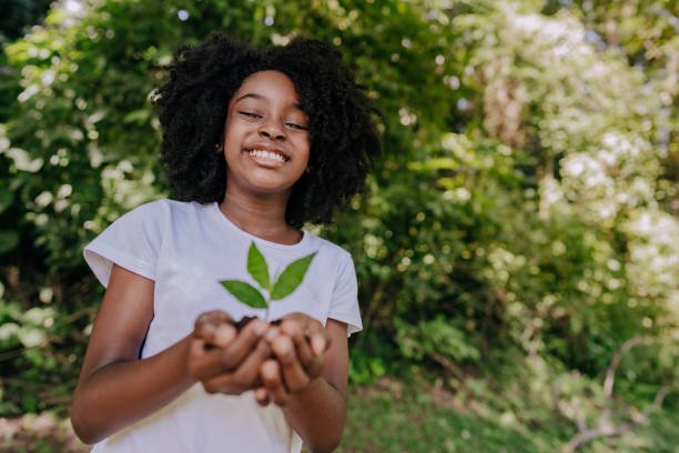 Child holding a small tree sapling